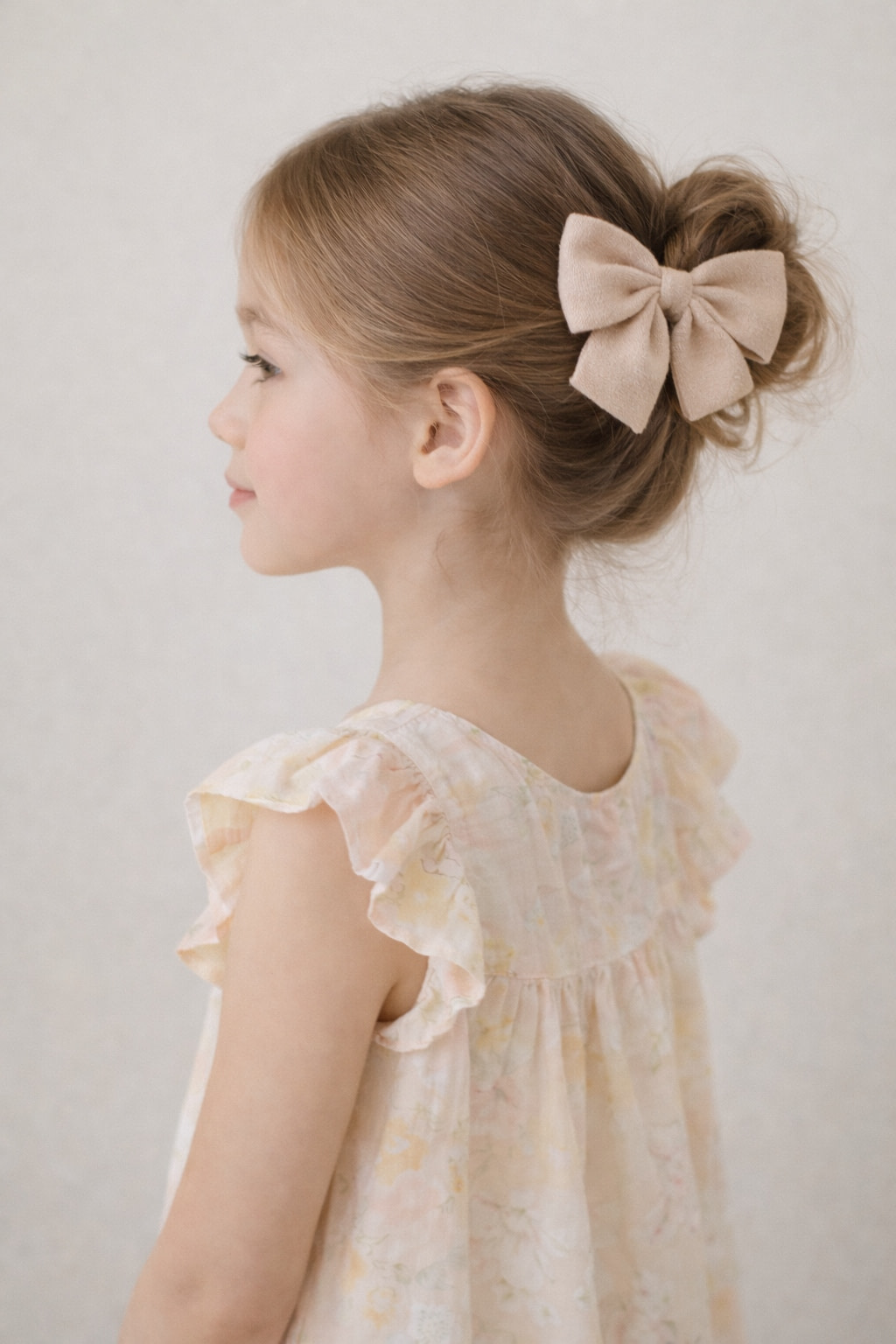 Home Girl wearing beige neutral hair bow in soft hairstyle