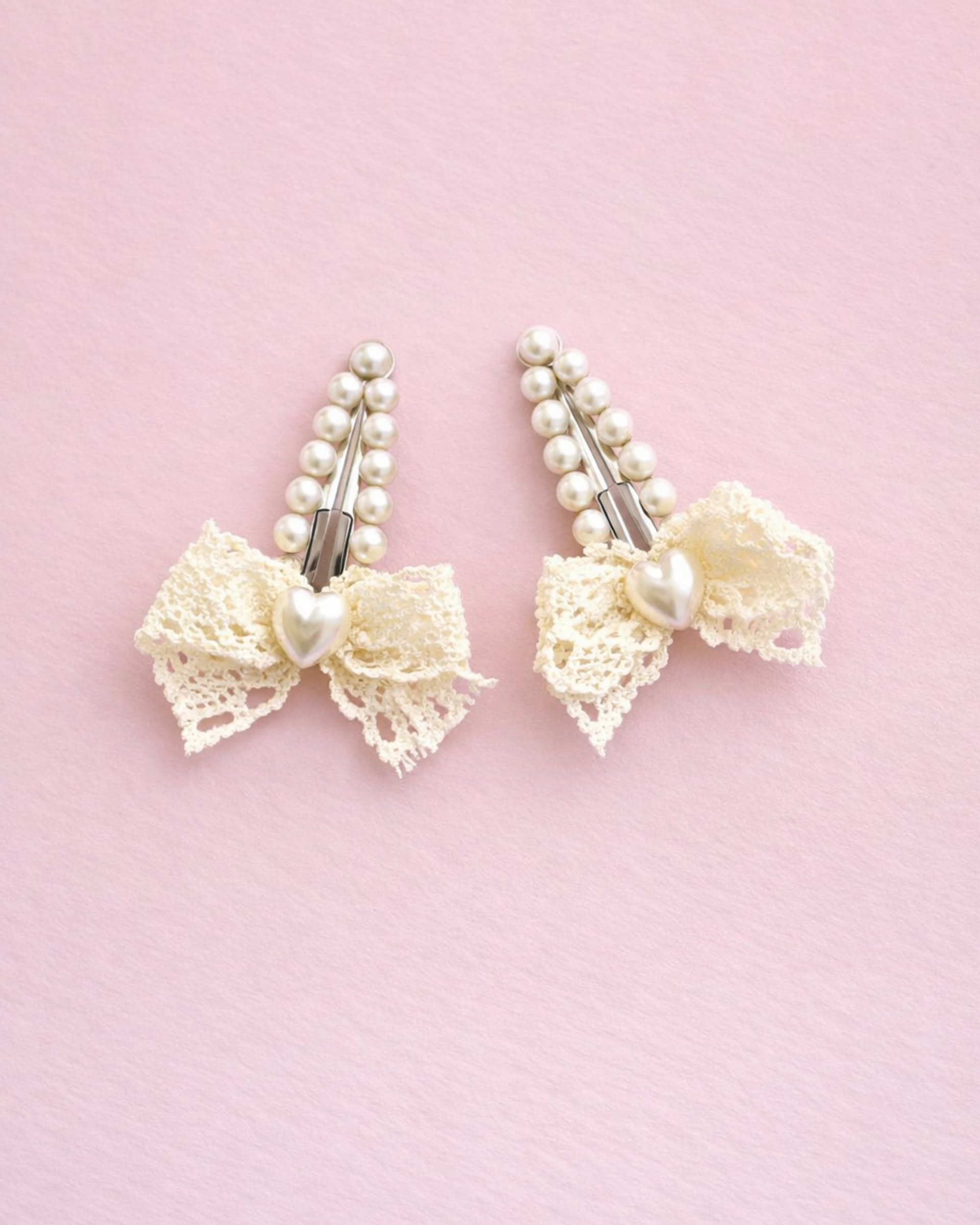 lace and pearls clips Pearl hair clips with ivory lace bows and heart-shaped pearl detail on a soft pink background
