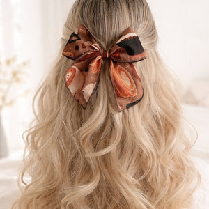 Home Brown patterned hair bow with soft tails on blonde hair